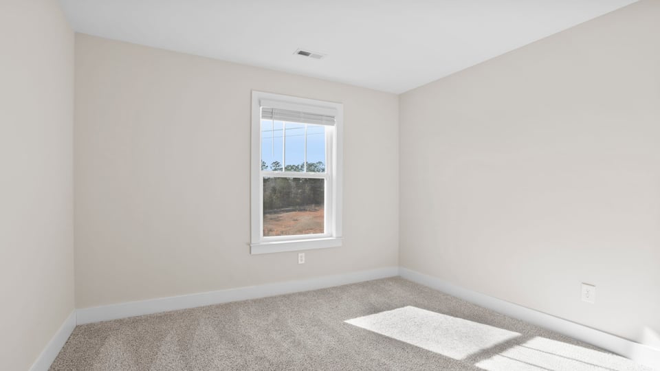 Bedroom with carpet and window.