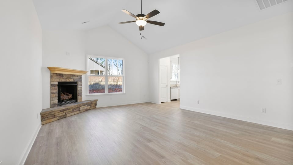 Family room with fireplace and ceiling fan.