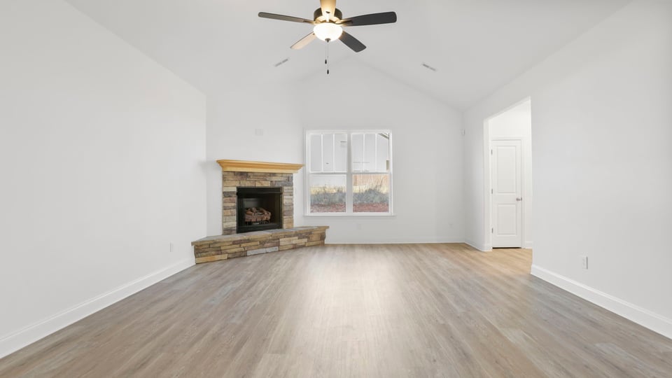 Family room with fireplace and ceiling fan.