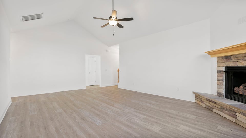 Family room with fireplace and ceiling fan.