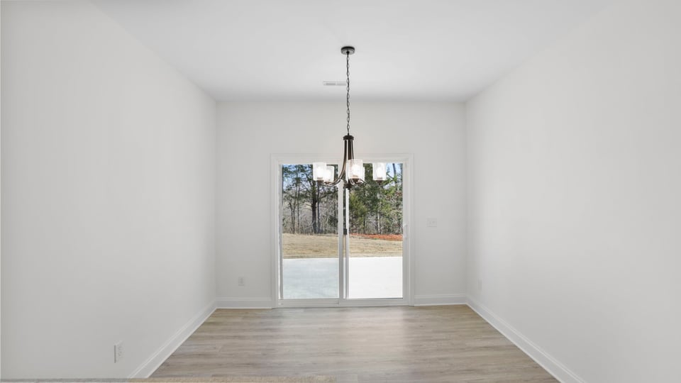 Dining room with chandelier and sliding doors.