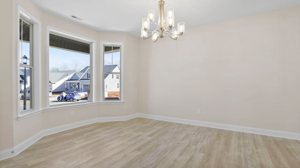 Dining room with chandelier and windows.