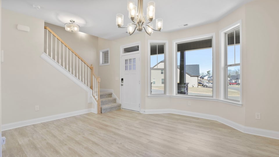 Dining room with chandelier and windows.
