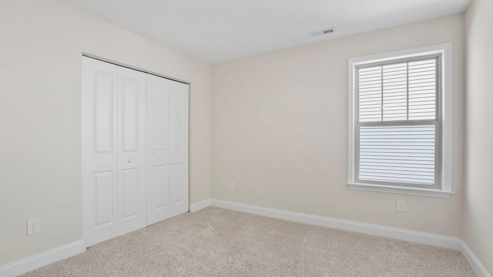 Bedroom with carpet and window.