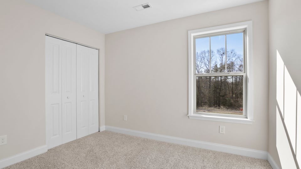 Bedroom with carpet and window.