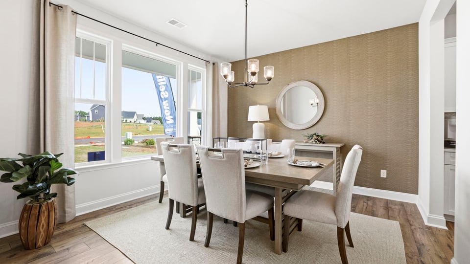 Formal dining room with large windows.
