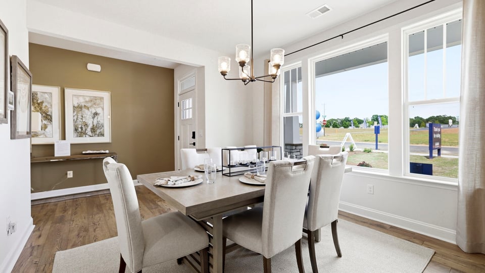 Formal dining room with large windows.