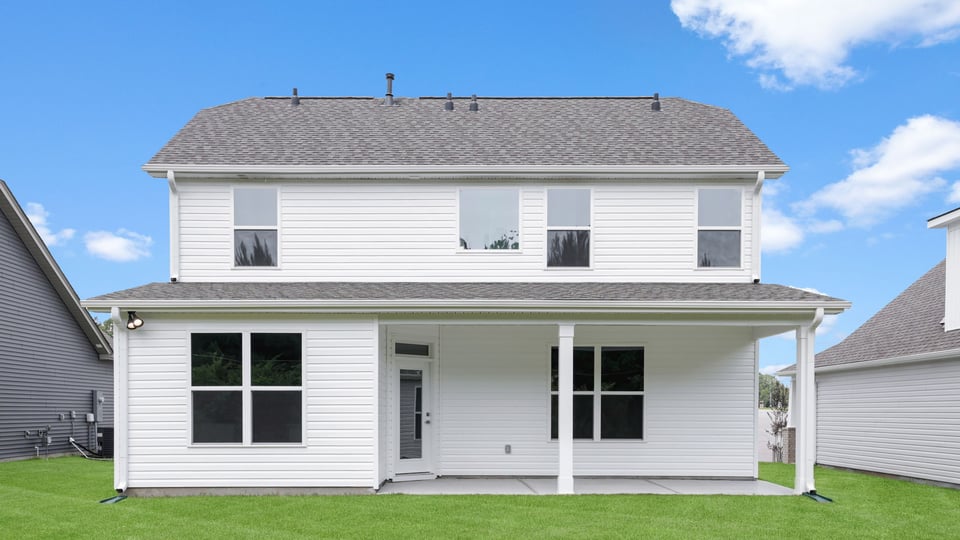 Back exterior of home with large backyard.