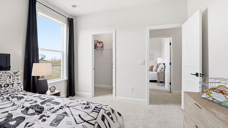Bedroom with carpet and large window.