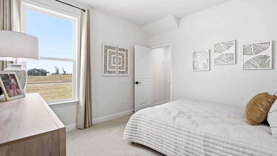 Bedroom with carpet and large window.