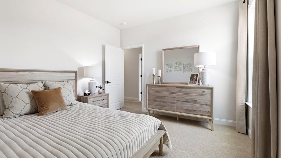 Bedroom with carpet and large window.