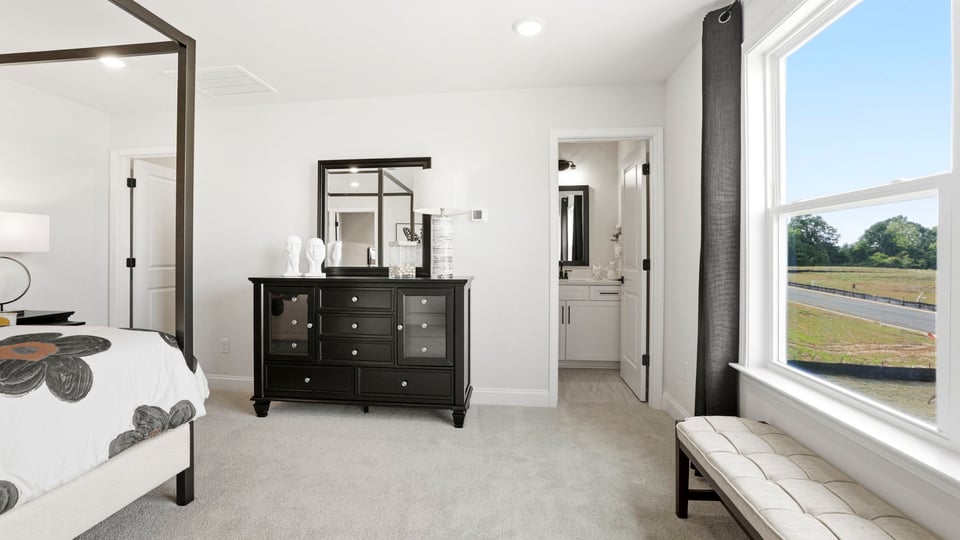 Bedroom with carpet and large window.