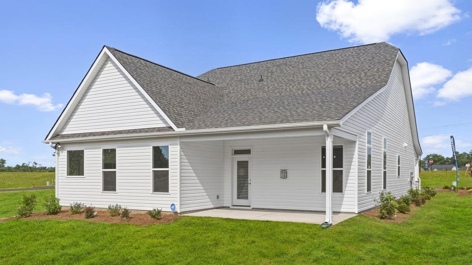 Exterior of home with covered porch and large backyard.