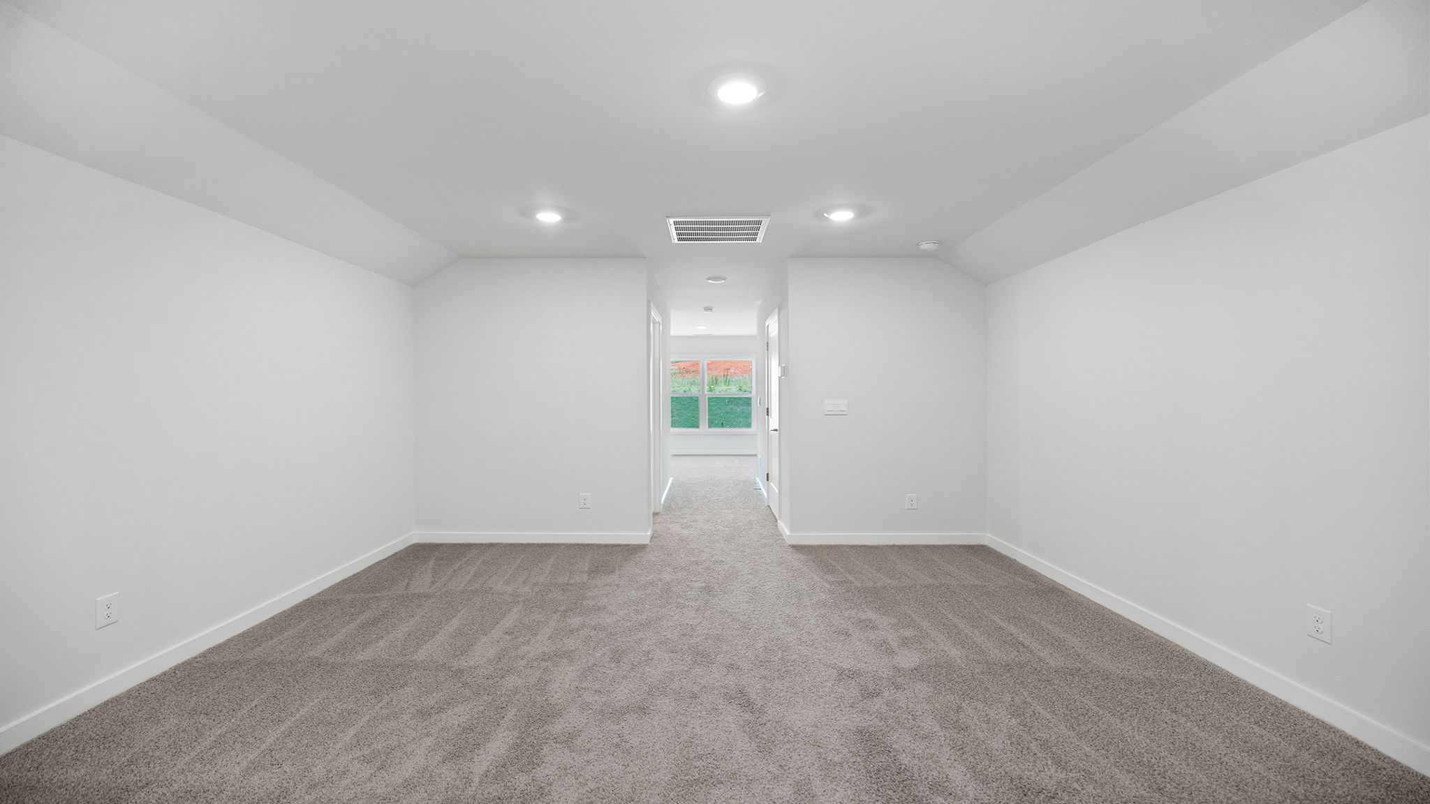 Loft with carpet and windows.