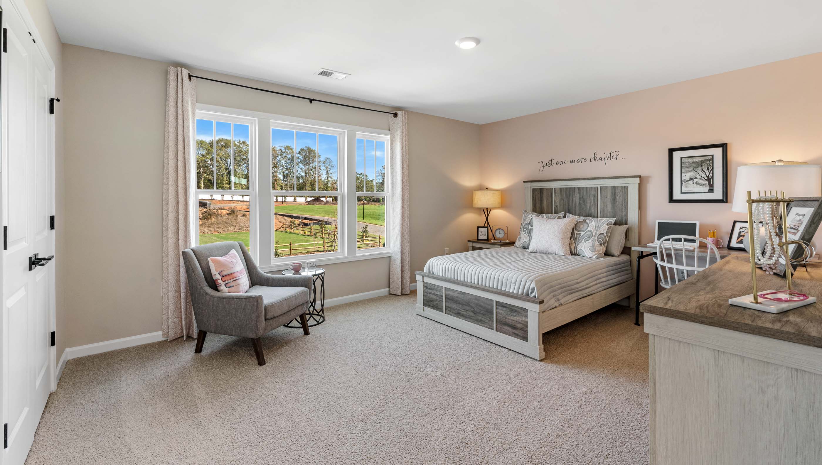 Primary bedroom with carpet and windows.