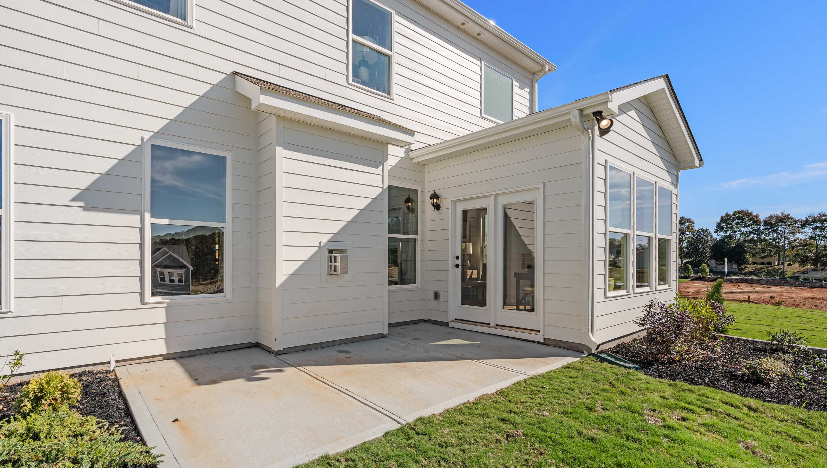 Back exterior with patio and large backyard.
