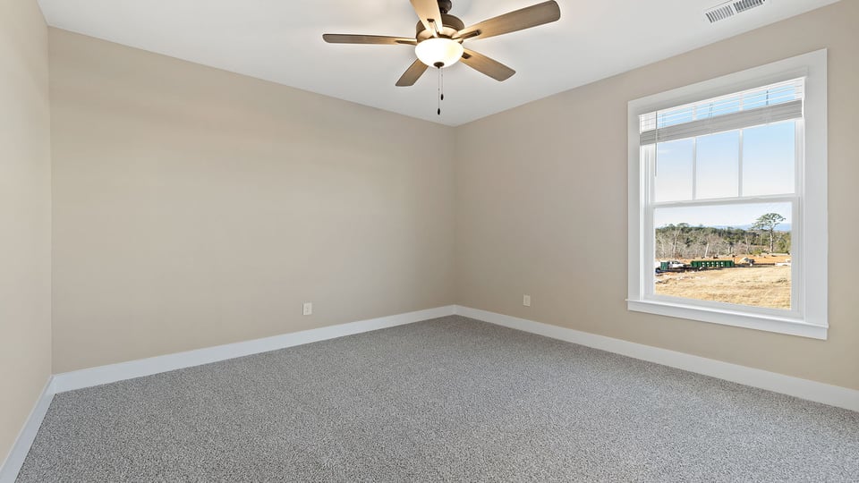 Bedroom with carpet and windows.