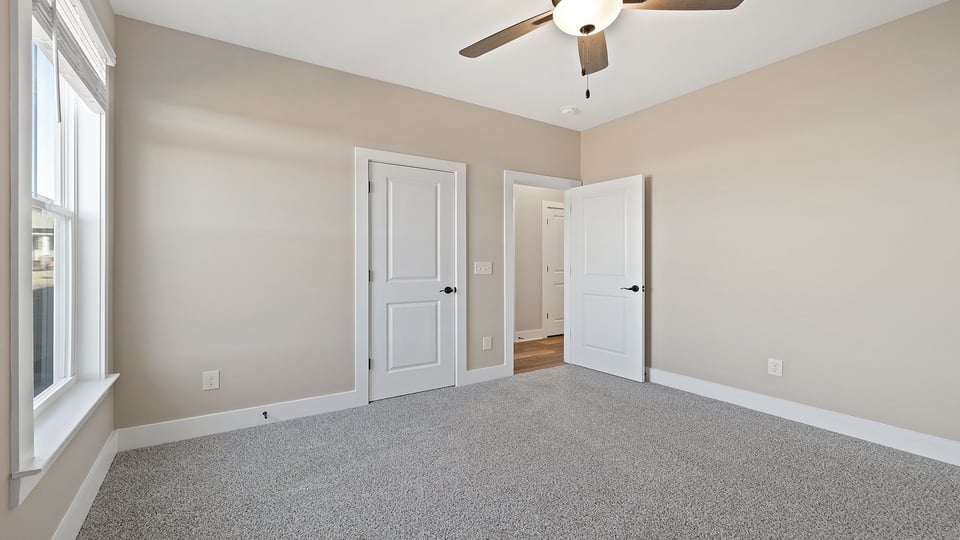Bedroom with carpet and windows.