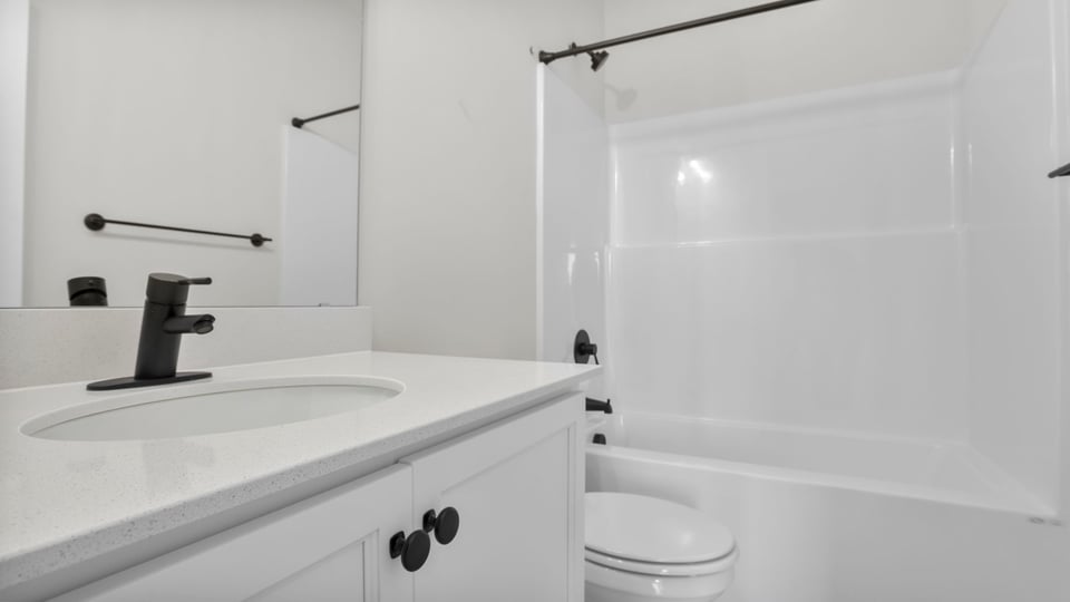 Hall bathroom with vanity and combination shower / tub.