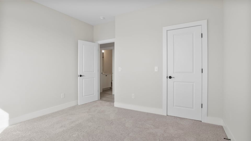 Front bedroom with large window and carpet.