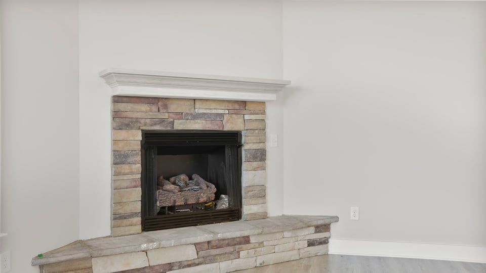 Close view of the gas log fireplace with stone accents.