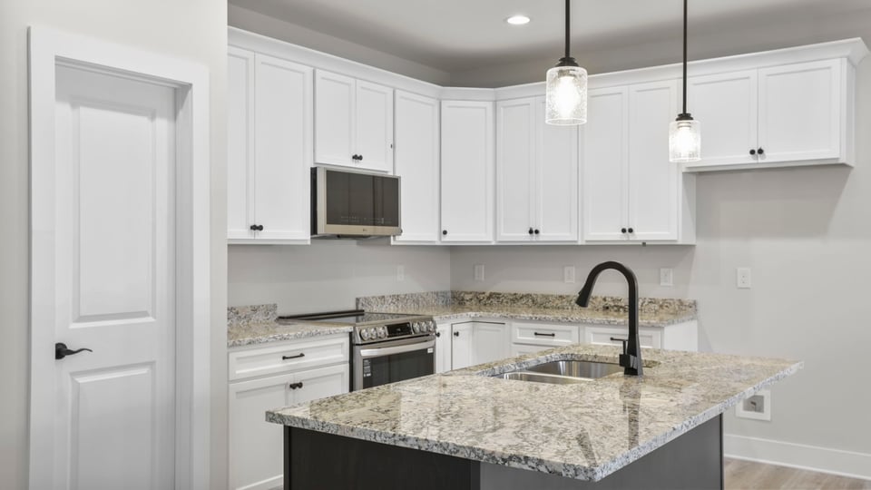 Kitchen and island feature quartz countertops and stainless-steel appliances.