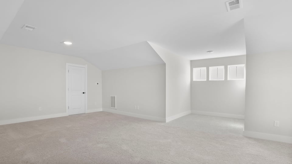 Upper-level bonus room with windows and carpet.