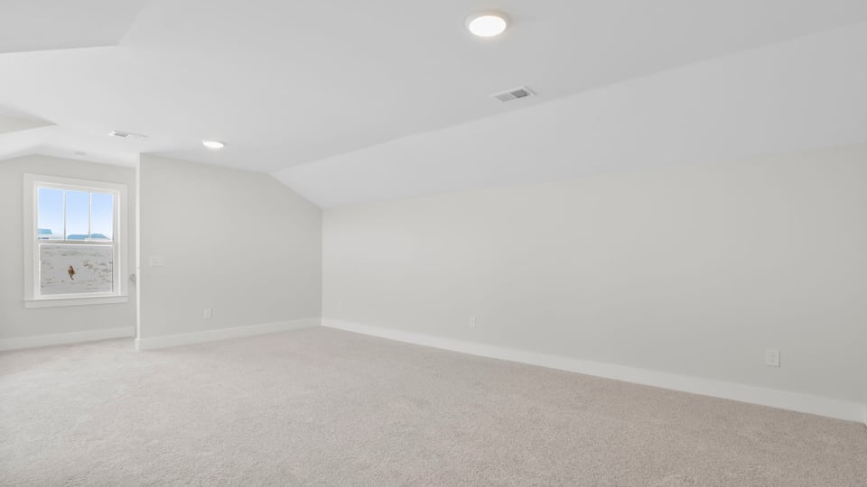 Upper-level bonus room with windows and carpet.