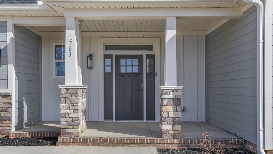 Inviting covered porch with stone accents.