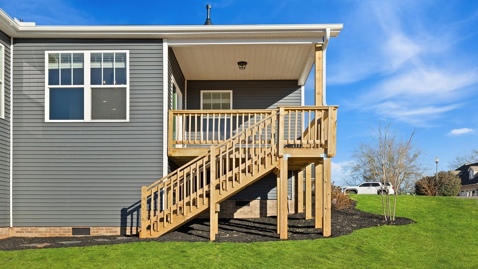 Back exterior with porch and large backyard.