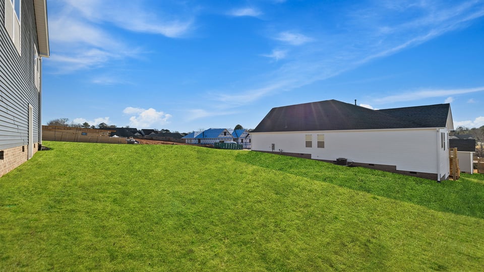 Back exterior with porch and large backyard.