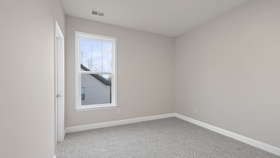 Bedroom with carpet and window.