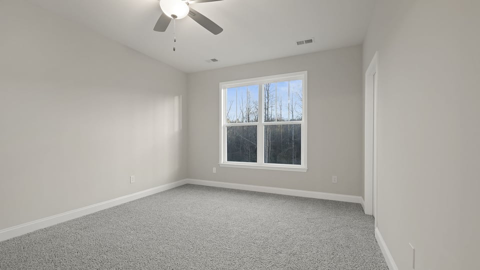 Bedroom with carpet and windows.