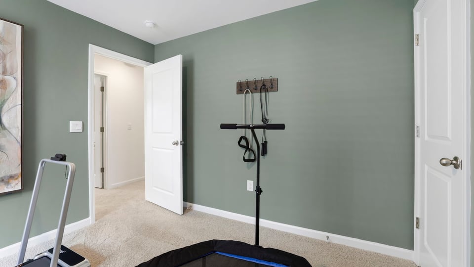 Bedroom used as gym with carpet and window.