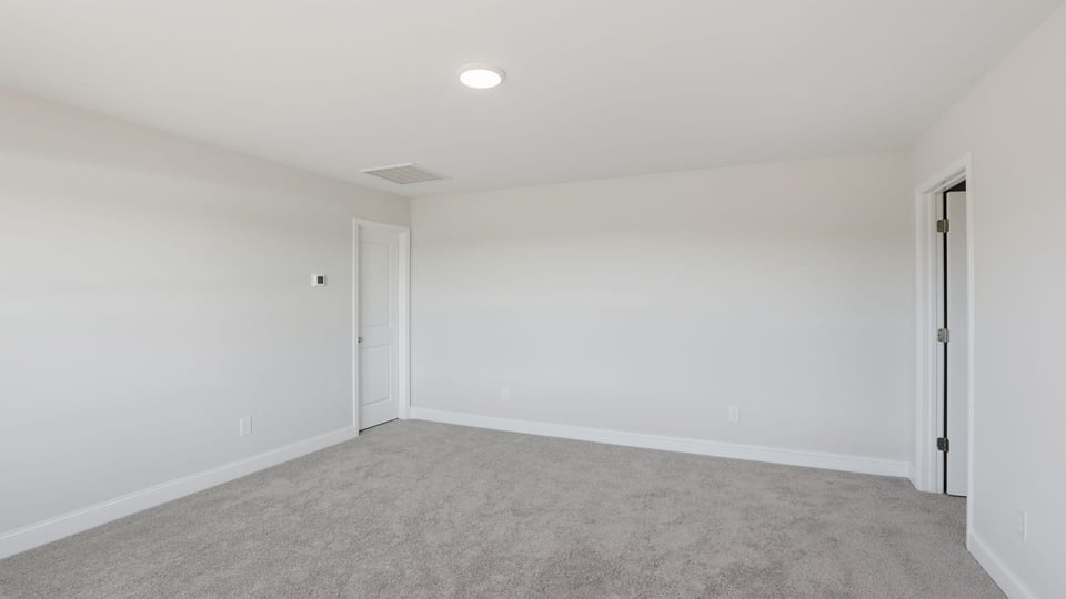 Bedroom with carpet and windows.