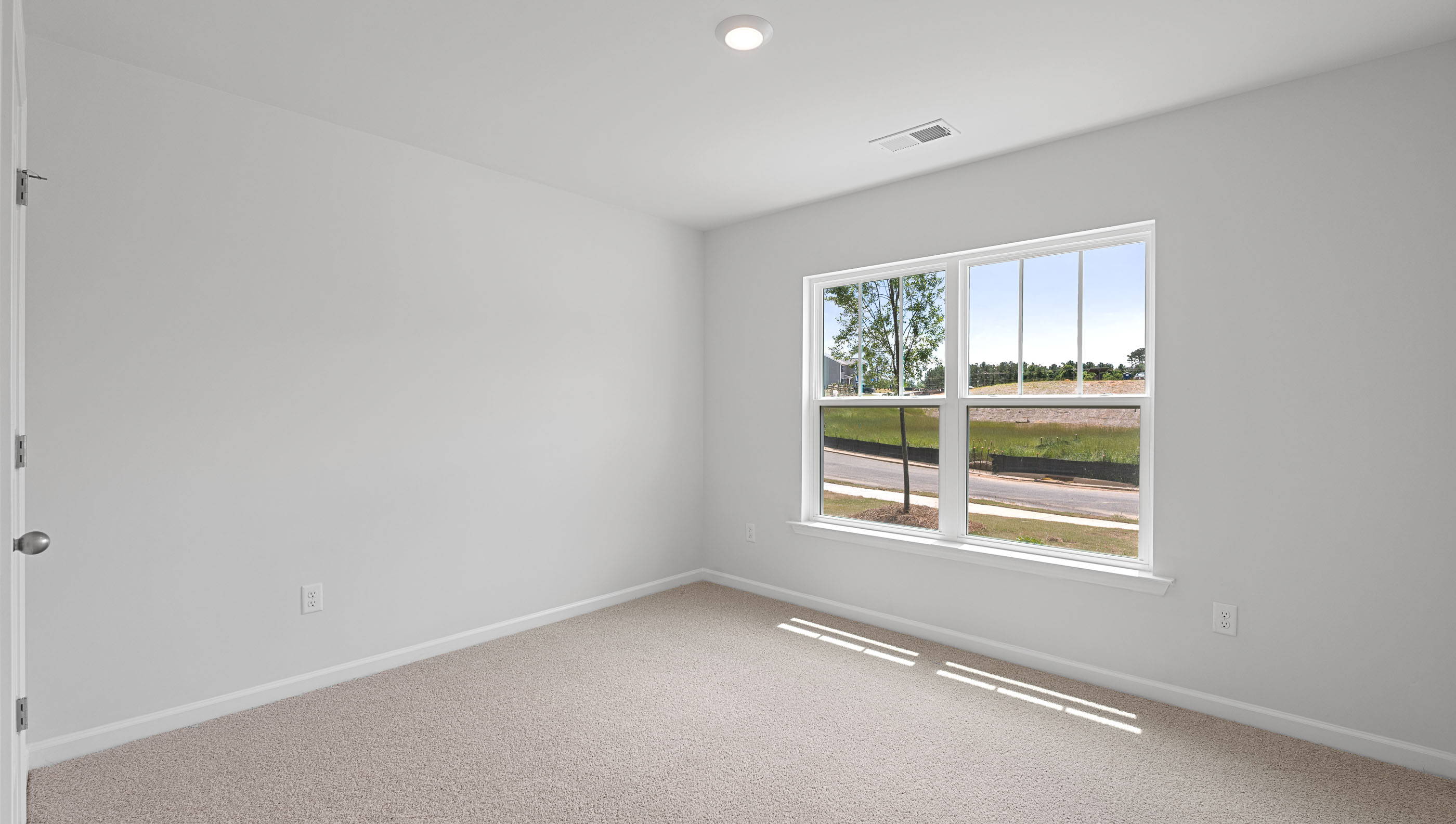 Bedroom with carpet and windows.