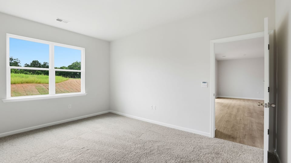 Primary bedroom with carpet and window