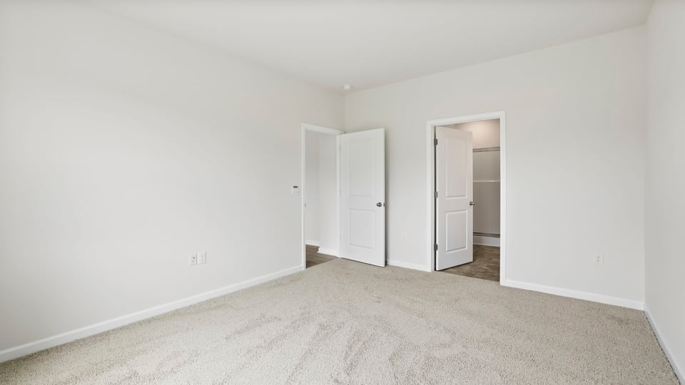 Primary bedroom with carpet and closet