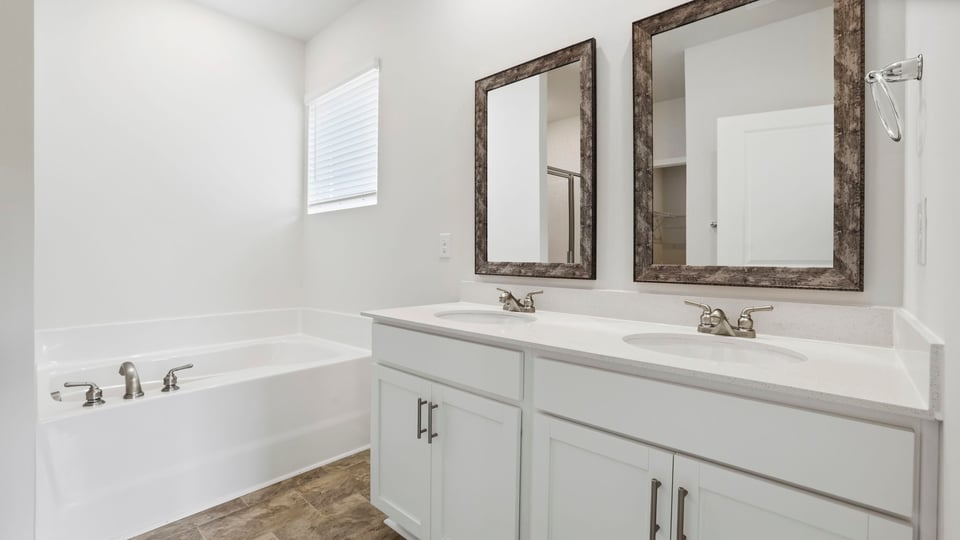 Primary bathroom with double vanity sink and tub