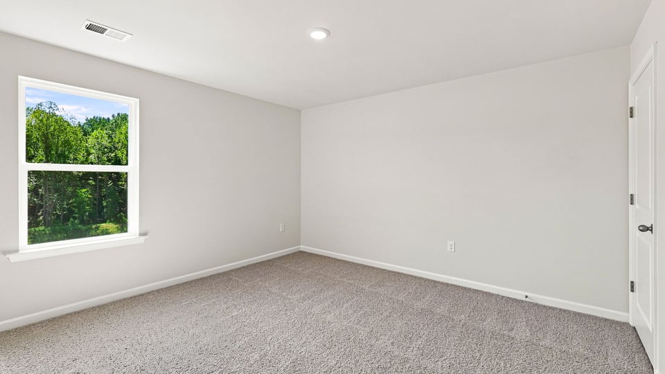 Bedroom with carpet and windows.