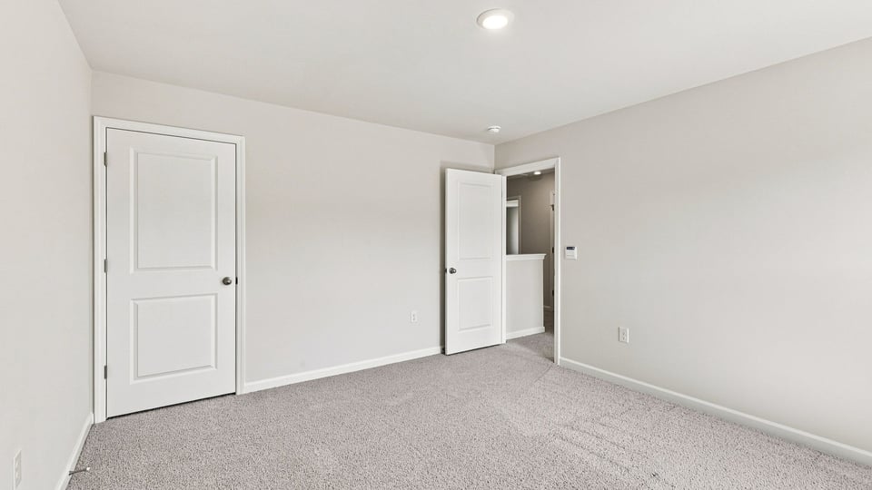 Bedroom with carpet and windows.