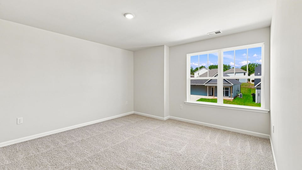 Bedroom with carpet and windows.