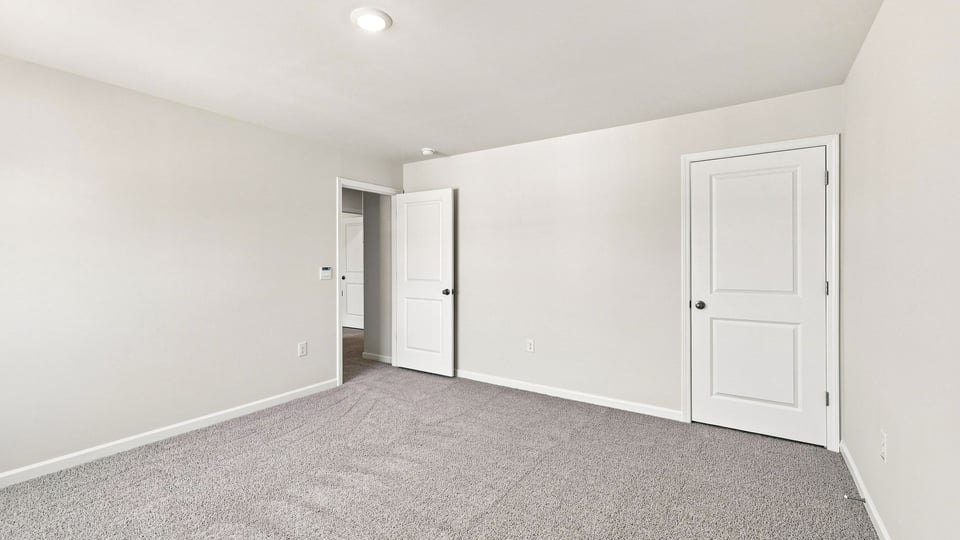 Bedroom with carpet and windows.