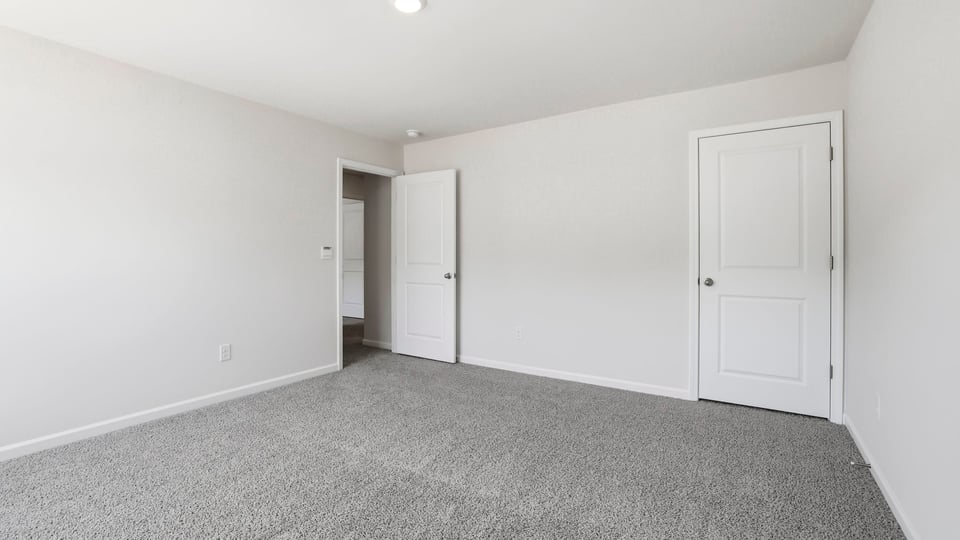 Bedroom with carpet and window.