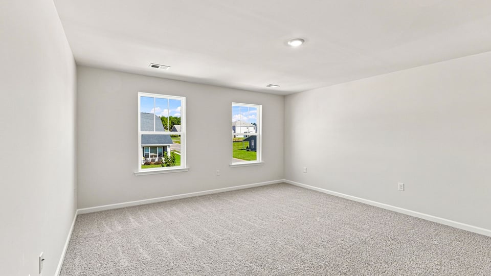 Bedroom with carpet and windows.