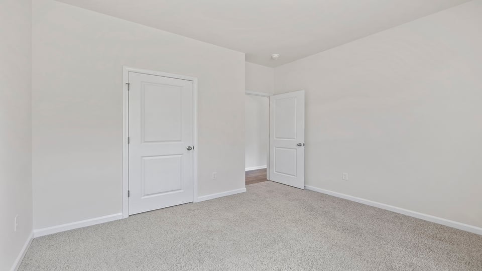 Bedrooom with carpet and windows.