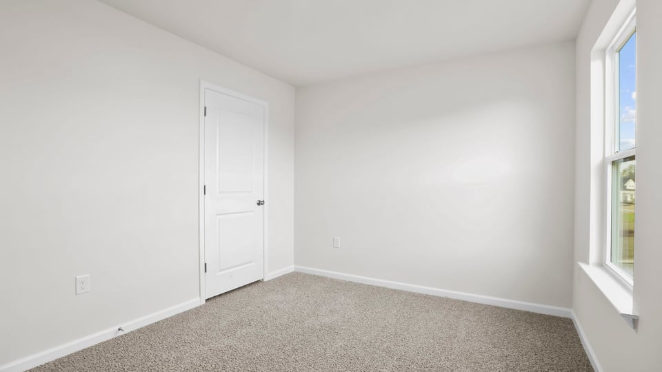 Bedroom with carpet and window.