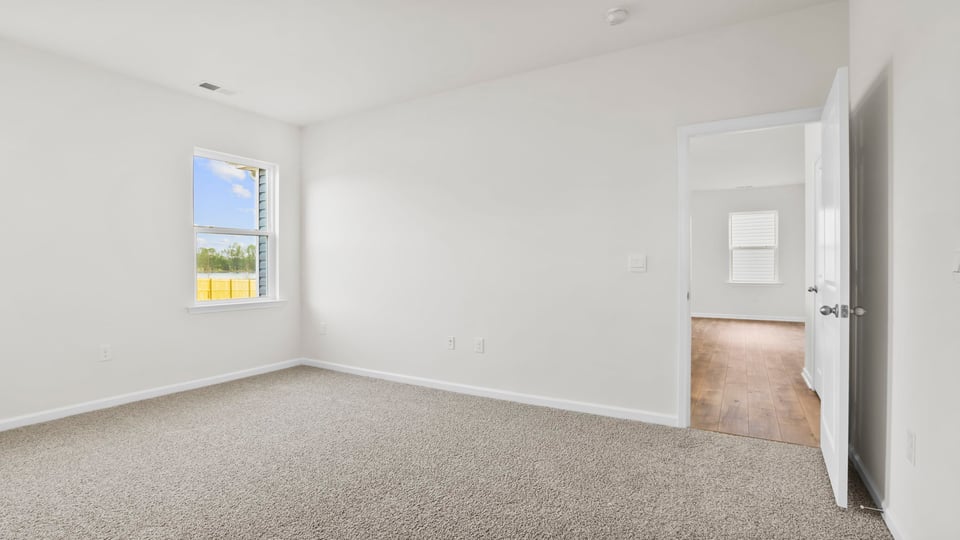 Bedroom with carpet and window.