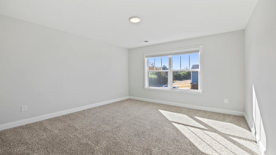 Bedroom with carpet and windows.