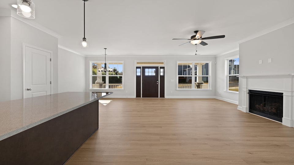 Family room with fireplace and ceiling fan.